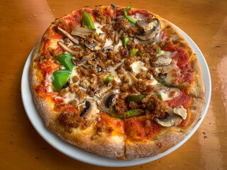 Personal pan pizza with sausage, green peppers, mushrooms, and onions 