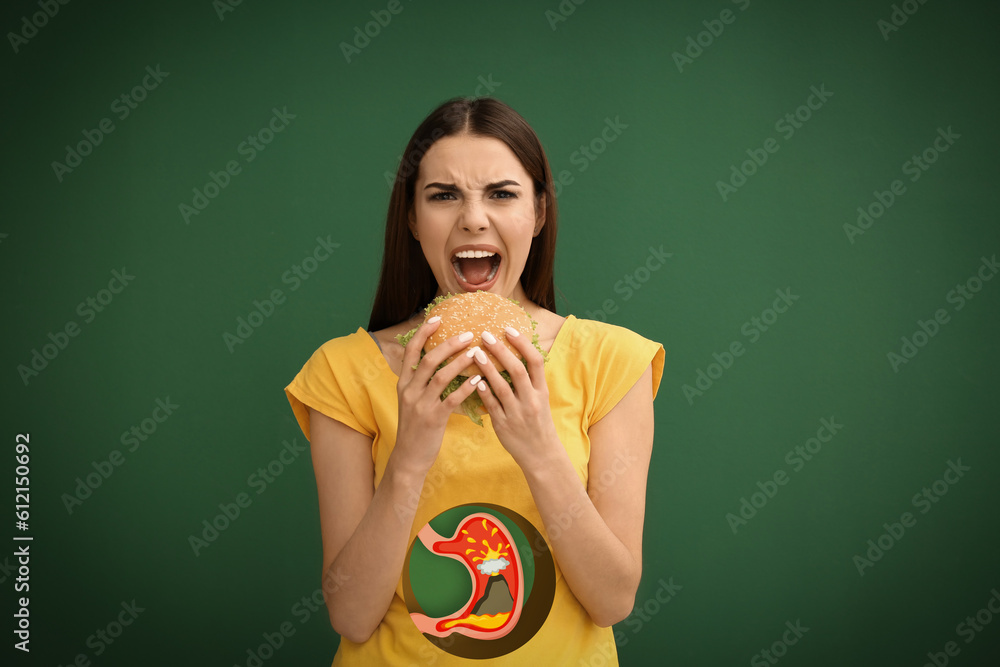 Canvas Prints Improper nutrition can lead to heartburn or other gastrointestinal problems. Woman eating burger on green background. Illustration of stomach with erupting volcano as acid indigestion