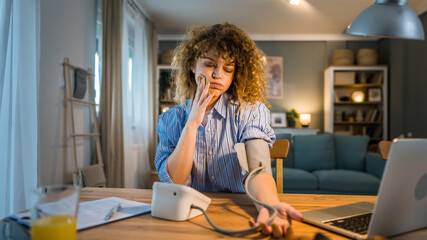 Obraz premium One woman caucasian female freelancer check blood pressure at home