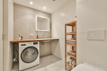 a small laundry room with a washer and dryer in the corner, next to a toilet on the floor