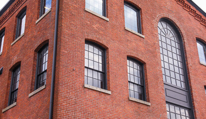 Fototapeta na wymiar Brick buildings with windows symbolize strength, stability, and urban progress, capturing the essence of business and industry