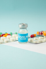 Side view of vaccine in medical ampoule packed pills capsules and disposable syringe