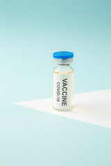 Top view COVID- VACCINE in a closed ampoule on blue wave background with free space