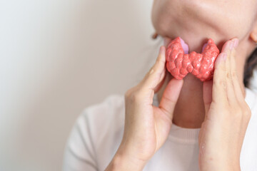 Woman holding human Thyroid anatomy model with her Neck. Hyperthyroidism, Hypothyroidism, Hashimoto Thyroiditis, Thyroid Tumor and Cancer, Postpartum, Papillary Carcinoma and Health concept