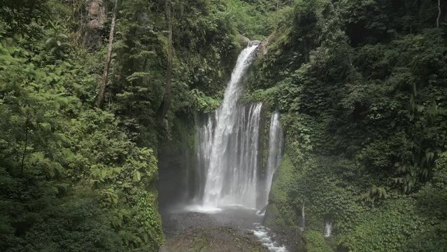 Misty Tiu Kelep waterfall falls through steep Lombok jungle foliage