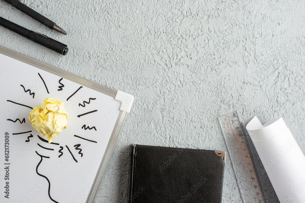 Wall mural top view of incompletely drawn thing and crushed wrapped paper on white desk notebook ruler on gray 