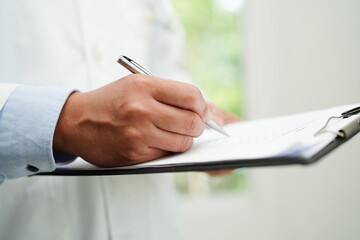 Doctor checking and note diagnosis medicine in clipboard of patients in hospital.