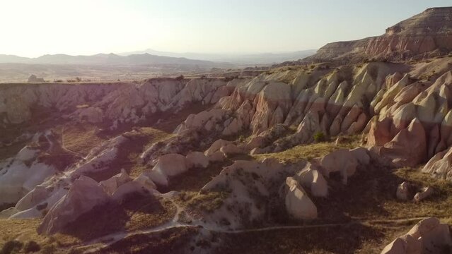 Drone view of Colorful red rose valley landscape in Cappadocia for sunset. Picturesque panoramic view of rock formations in the valley, Turkey