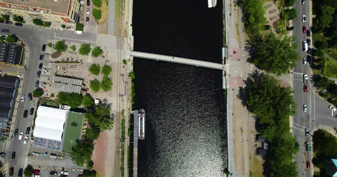 Aerial view tilting over the Canal de Lachine, toward the Saint Lawrence river, in sunny Montreal, Canada