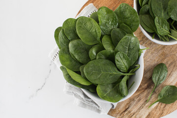 Fresh baby raw spinach on a plate. Copy space. Healthy eating.