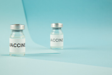 Top view of vaccine ampoules on blue wave background with free space