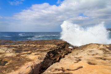 Waves crashing over rocks off the Sydney coast