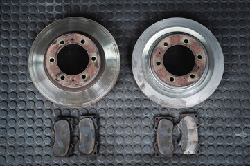 Worn car brake pads and brake rotors .