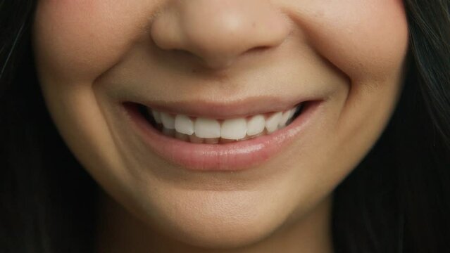 Closeup dental care and stomatology concept 4K. Slow motion happy caucasian woman with beautiful skin smiling to camera, showing white smile after teeth alignment and zoom teeth whitening procedure