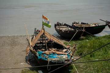 Two fishing boats with Indian flag anchored on the bank of river Ganga for taking rest.