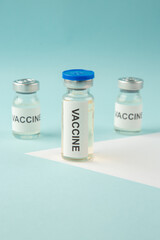 Vertical view of vaccine ampoules on pastel blue and white background with free space
