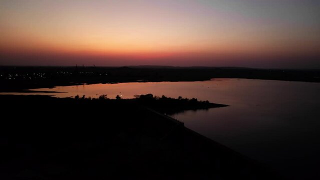 golden hour red sky reflecion on the reservoir drone shot 4k 30p
