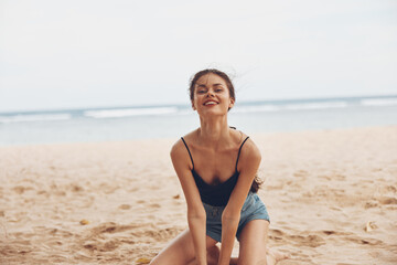 Fototapeta na wymiar woman vacation freedom sitting sand beautiful travel sea nature beach smile