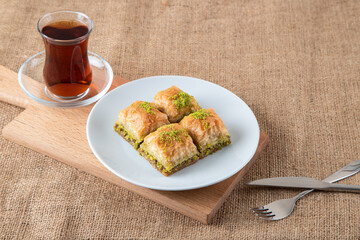 Traditional pistachio baklava with Turkish tea.A plate of baklava burlap sack