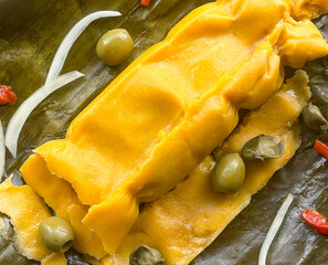 Close up of a hallaca typical Venezuelan Christmas dish, around some ingredients used for its preparation. Selective focus.