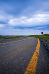 Fototapeta premium Beautiful empty winding road with signpost