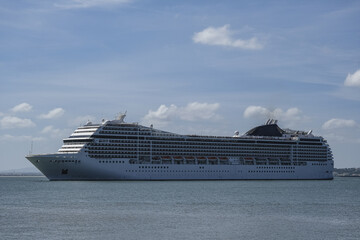 Large modern liner cruiseship cruise ship Poesia, Orchestra, Magnifica or Musica in port of Lisbon, Portugal during Mediterranean cruising with city skyline, Christos statue and suspension bridge