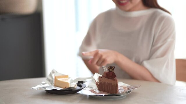 どちらのケーキを食べるか悩む女性