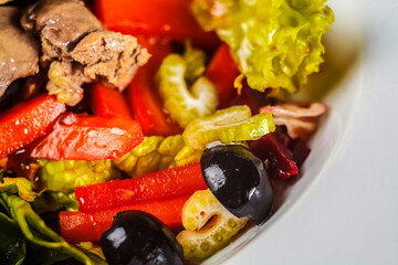 A colorful, freshly-prepared salad filled with olives, red peppers and other vegetables for a delicious and nutritious meal that promotes healthy eating and wellbeing.