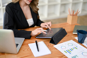 A businesswoman using her digital tablet at her desk in the office.