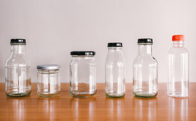 empty used glass bottle on wood desk with gray background. Recycle glass bottles and safe the earth concept. 