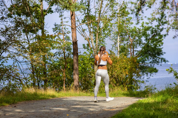 Fototapeta premium Woman Walking In Woodland During Outdoor Workout