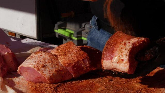 Slow motion seasoning of pork meat at a grill festival