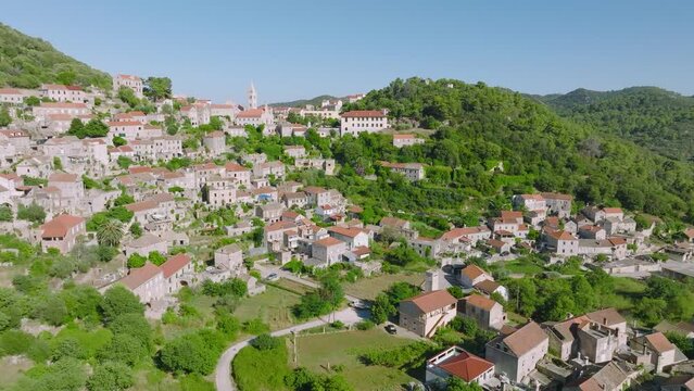 Stunning Landscape View Of A Village On Lastovo Island Bounded By Lush Green Trees On Mountains In Southern Croatia. aerial, wide shot