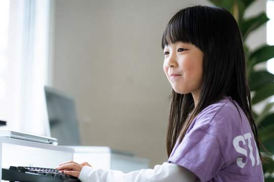 パソコンを使い勉強する日本人の女の子