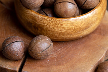 Unpeeled macadamia nuts on a wooden table