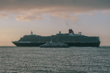 Luxury ocean liner cruiseship cruise ship Victoria or Elizabeth in port of Lisbon, Portugal during Mediterranean cruising with city skyline, Christos statue and suspension bridge