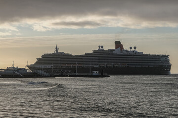 Luxury ocean liner cruiseship cruise ship Victoria or Elizabeth in port of Lisbon, Portugal during Mediterranean cruising with city skyline, Christos statue and suspension bridge