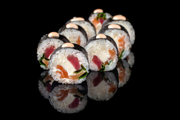 appetizing sushi roll futomaki on a black background with reflection. Sushi menu. Japanese kitchen, restaurant.