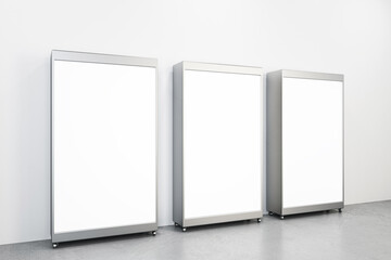 Perspective view on three modern billboards with blank white screens for advertising text or marketing campaign, logo brand on concrete floor and light wall background. 3D rendering, mockup