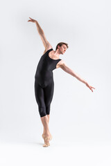 Ballet Dancer Young Athletic Man in Black Suit Posing in Stretching Dance Pose Studio On White.