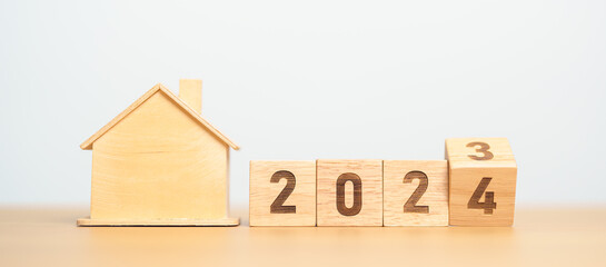 flip 2023 to 2024 block with house model. real estate, Home loan, tax, investment, financial, savings and New Year Resolution concepts