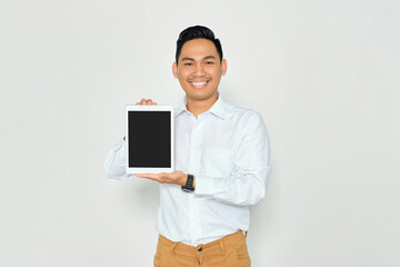 Mockup for advertising. Happy young Asian man in formal wear showing digital tablet blank screen with smile isolated on white background