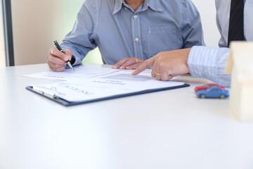 Sales manager giving advice application form document, considering mortgage loan offer for car and house insurance.