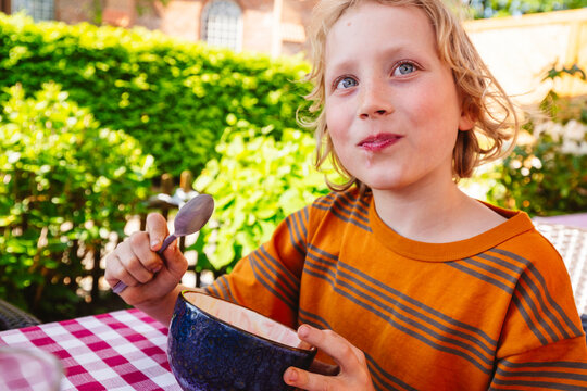 Blond Boy Eating Desert In Bowl