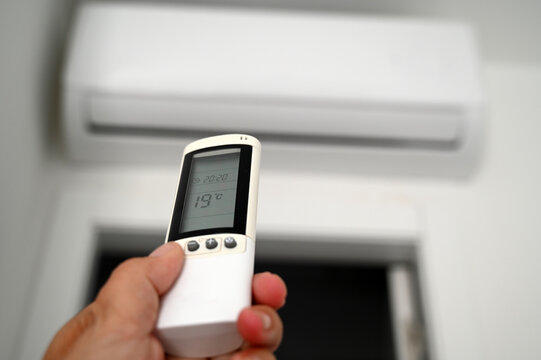 R&eacute;glage de la climatisation avec une t&eacute;l&eacute;commande en main