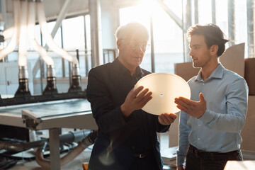Businessmen discussing over machine part in industry