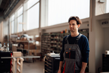Smiling carpenter standing in workshop