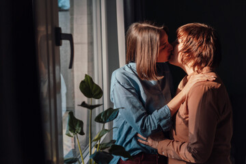 Affectionate lesbian couple kissing each other at home
