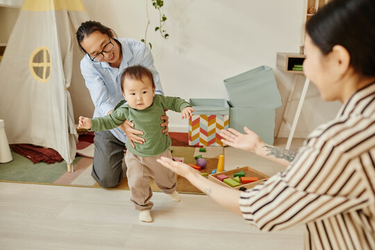 Cute daughter taking first steps towards mother at home
