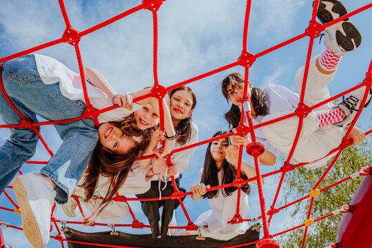 Teenage friends playing on jungle gym at park